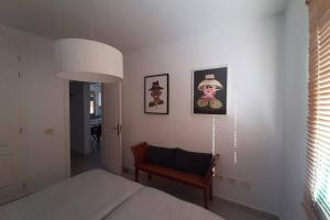 a bedroom with a bed and a chair and pictures on the wall at El Pasadizo - The secret passage-Puerto del Carmen in Puerto del Carmen