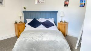 a bedroom with a large bed with two lamps at Rose Apartment in Totnes