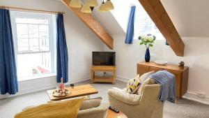 a living room with a couch and a tv at Rose Apartment in Totnes