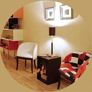 uma sala de estar com uma cadeira e uma mesa com um candeeiro em Hostal San Isidro em Autol
