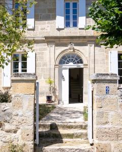 una entrada a un edificio de piedra con una puerta blanca en La Girondine, en Saint-Philippe-dʼAiguille