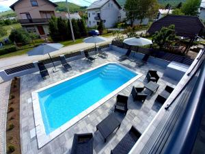 an overhead view of a swimming pool with chairs and umbrellas at Premier House by RD Group in Korenica