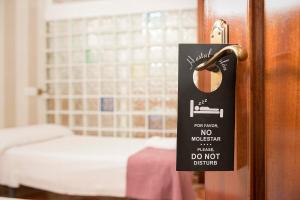 Postel nebo postele na pokoji v ubytování Hostal Colón