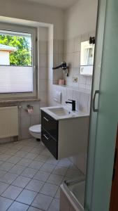 a bathroom with a sink and a toilet at Pension "Am Fischerweg" in Heringsdorf +32 photos