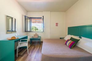 カステッランマーレ・デル・ゴルフォにあるUlivo Blu Holiday Homesのベッドルーム1室(ベッド1台、デスク、ベッドサイドシックスシックス付)