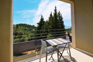 a balcony with a table and chairs on a balcony at La Perle d'Eze - Aparthotel in Éze