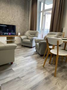 - un salon avec une télévision, une table et des chaises dans l'établissement Апартаменты Ясная Поляна, à Odessa