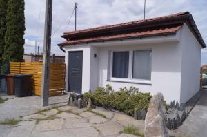 ein kleines weißes Haus mit einer schwarzen Tür in der Unterkunft Apartament Pisz in Pisz