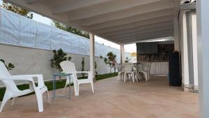 een patio met witte stoelen en een tafel bij villa Roby in Trappeto