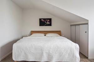 ein Schlafzimmer mit einem Bett mit einer weißen Decke in der Unterkunft Ferienwohnung Rosenrot am See in Konstanz