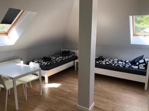 2 łóżka w pokoju ze stołem, stołem i krzesłami w obiekcie Klimatyzowane Apartamenty i Pokoje przy Targach Kielce w Kielcach