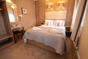 Station House Bed & Breakfast في إينيستيمون: غرفة فندق عليها سرير وفوط