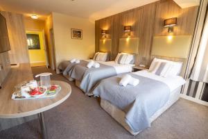 een hotelkamer met 2 bedden en een tafel bij Station House Bed & Breakfast in Ennistymon