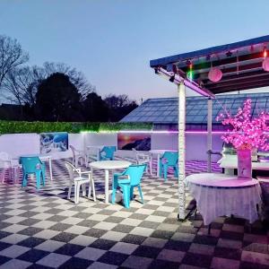a patio with tables and chairs on a checkered floor at Cat Villa Kawajimamachi in Kawagoe