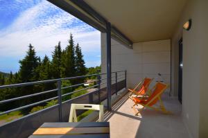 a balcony with two chairs and a view of trees at La Perle d'Eze - Aparthotel in Éze