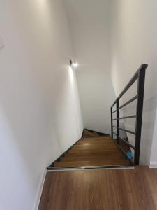 a staircase with a metal railing and a wooden floor at Haus Am Meer in Mieroszyno +1 photo