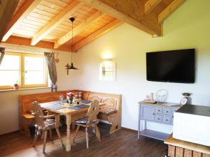 una sala da pranzo con tavolo e TV a parete di Ferienwohnung Reisach a Lindenberg im Allgäu