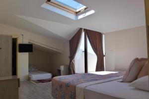 a bedroom with two beds and a skylight at Kandıra Butik Hotel in Çeşme +70 photos