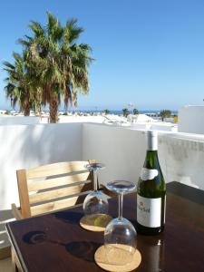 El Pasadizo - The secret passage-Puerto del Carmen في بويرتو ديل كارمن: طاولة مع كأسين وزجاجة من النبيذ