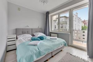 a bedroom with a bed and a large window at Grand Apartments - Silver Sands Sopot Apartment in Sopot