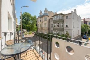 a balcony with tables and chairs and buildings at Grand Apartments - Silver Sands Sopot Apartment in Sopot