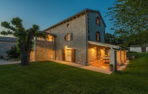 une grande maison en briques avec un arbre dans la cour dans l'établissement Family Villa Kata San Lorenzo, à Vošteni
