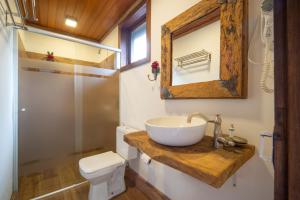 W łazience znajduje się umywalka, toaleta i lustro. w obiekcie Aires de Patagonia w mieście Cambará