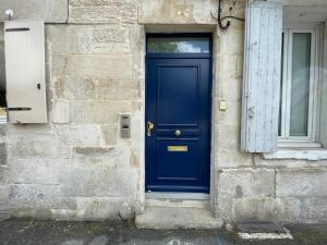 una puerta azul en el lateral de un edificio en Chez Emile Le Rose Bonbon-Tout Neuf avec Netflix, en Niort