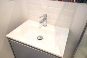 ein weißes Waschbecken mit einem Wasserhahn in der Unterkunft Chez Emile Le Rose Bonbon-Tout Neuf avec Netflix in Niort