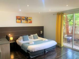 a bedroom with a bed and a large window at Hotel & Spa Gil de France Cap d'Agde in Cap d'Agde