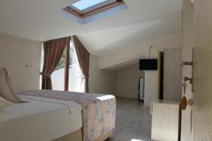 a bedroom with a bed and a skylight at Kandıra Butik Hotel in Çeşme