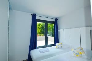 a bedroom with two beds and a large window at La Perle d'Eze - Aparthotel in Éze