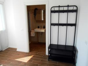 een badkamer met een wastafel en een zwarte plank bij VCE House in Tessera
