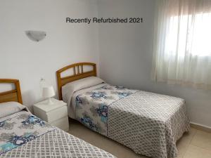 a bedroom with two beds and a window at VicAm Atico Duplex in Pineda de Mar