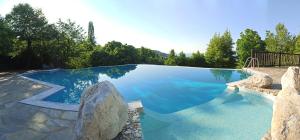 a large swimming pool with a rock and blue water at Aroma Piliou - Άρωμα Πηλίου in Mouresi