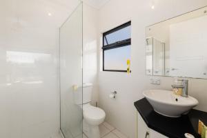 a white bathroom with a sink and a toilet at Swainson on 1 Lexington - 200m to Beach! in Henley Beach +22 photos