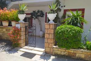 einen Eingang zu einem Haus mit Blumen und Pflanzen in der Unterkunft Christina's House in Parga