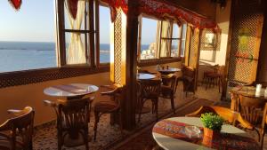 een restaurant met tafels en stoelen en uitzicht op de oceaan bij Misr Hotel in Alexandrië