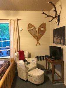 a living room with two chairs and a tv at Holiday Lodge Cabins in Banff