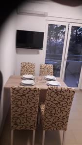 a dining room table with two chairs and a television at Apartments VRSI 4494 in Vrsi