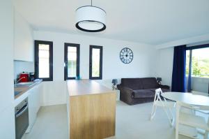 a kitchen and living room with a couch and a table at La Perle d'Eze - Aparthotel in Éze