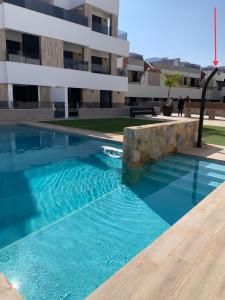 a swimming pool in front of a building at Penthouse Las 2 Salchichas in San Javier