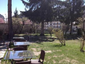 un patio avec des tables et des chaises dans un parc dans l'établissement Villa Myosotis, à Bardonnèche