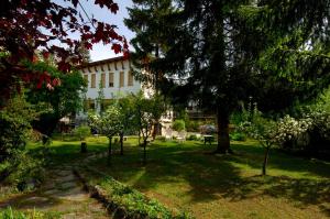 un bâtiment dans un parc avec des arbres et de la pelouse dans l'établissement Villa Myosotis, à Bardonnèche