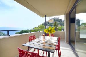 a dining table and chairs on a balcony with a view at La Perle d'Eze - Aparthotel in Éze