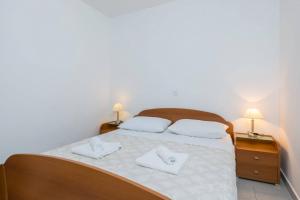 ein Schlafzimmer mit einem Bett mit zwei weißen Handtüchern darauf in der Unterkunft Apartment in Orebic with terrace, air conditioning, WiFi, washing machine (4934-3) in Orebić