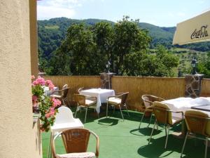 a patio with tables and chairs and a fence at Penzión na Slnečnej stráni in Vyhne