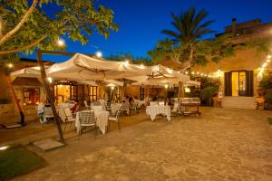 restauracja z białymi stołami i krzesłami w nocy w obiekcie Hotel Baglio Oneto dei Principi di San Lorenzo - Luxury Wine Resort w mieście Marsala