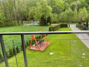 d'un balcon avec un banc sur la pelouse. dans l'établissement Bratkowa Dolina, à Szczyrk