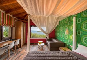 a bedroom with a bed and a couch and a window at Thalassokipos in Vourvourou